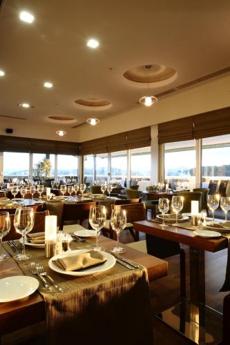 a restaurant with tables and chairs with wine glasses at Ramada by Wyndham Podgorica in Podgorica