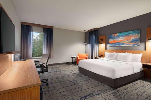 een hotelkamer met een bed, een bureau en een televisie bij La Quinta Inn & Suites by Wyndham Marysville in Marysville