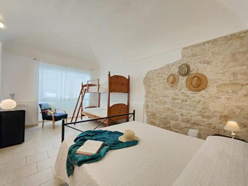a bedroom with a bed and a stone wall at siciliacasevacanze - Pola Home in Marina di Ragusa