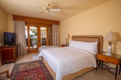 a bedroom with a large white bed and a television at Beautiful villa at Four Seasons in Sharm El Sheikh