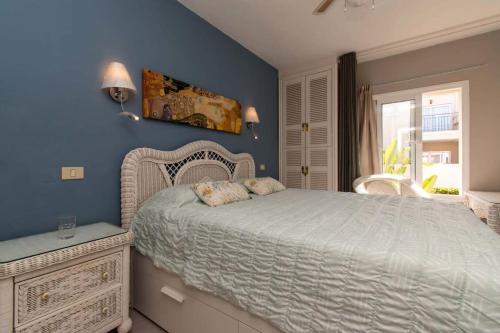 a bedroom with a bed and a blue wall at Los Olivos 13 - One Bed in Adeje