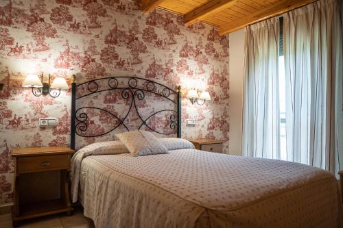 - une chambre avec un grand lit et du papier peint rose dans l'établissement Apartamentos Naspún, à Campo