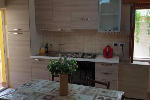 una cucina con tavolo e pianta in vaso di Borgo San Giorgio Apartment a Castelmola