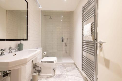 a bathroom with a toilet and a sink and a shower at Central Soho Loft with A C & Concierge in London