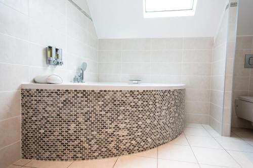 a bathroom with a tub and a sink at Château de la Folie in Trie-Château