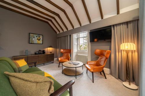 a living room with a green couch and orange chairs at The Scott in Edinburgh