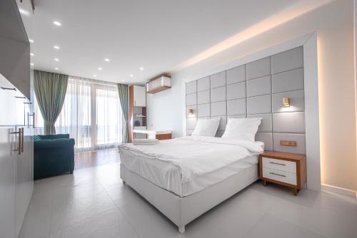 a bedroom with a large white bed and a blue couch at SunRise Beach in Venus
