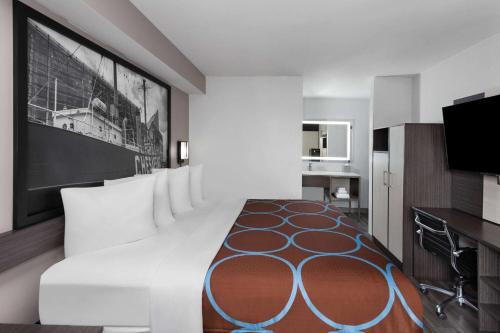 a bedroom with a large white bed and a television at Super 8 by Wyndham Baltimore Northwest in Baltimore
