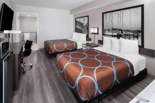 a hotel room with two beds and a desk at Super 8 by Wyndham Baltimore Northwest in Baltimore