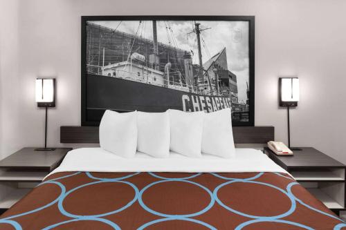 a bedroom with a large bed with a ship on the wall at Super 8 by Wyndham Baltimore Northwest in Baltimore
