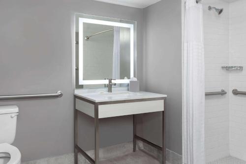 a bathroom with a sink and a mirror and a toilet at Days-Inn by Wyndham Baltimore Northwest in Baltimore