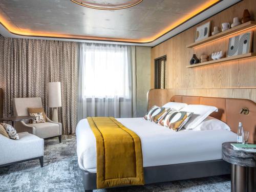 une chambre d'hôtel avec un lit et une chaise dans l'établissement Pullman Lyon, à Lyon