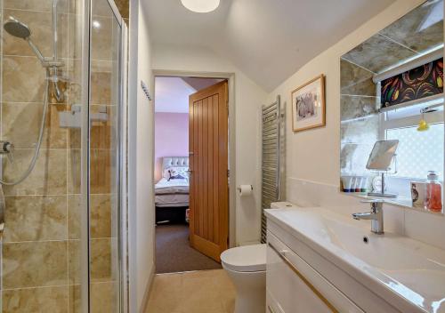 a bathroom with a shower and a sink and a toilet at Victoria Cottage - Wensum Retreats in Gunthorpe