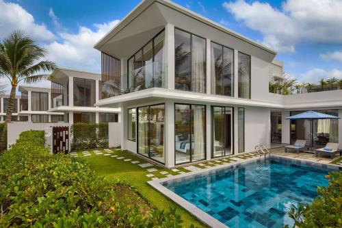 una imagen de una casa con piscina en Wyndham Hoi An Royal Beachfront Resort & Villas en Hoi An
