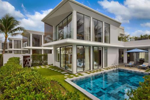 an image of a house with a swimming pool at Wyndham Hoi An Royal Beachfront Resort & Villas in Hoi An