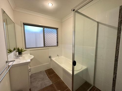 a bathroom with a tub and a sink and a shower at Four bedroom large family home close to Ipswich city in Ipswich