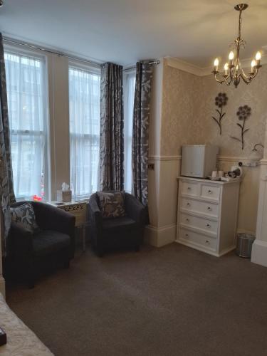 a living room with a couch and a chair and windows at Sunflower Lodge in Bridlington