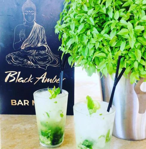 a couple of glasses of water with a buddha drink at BLACK AMBER BOUTIQUE HOTEL in Lampi