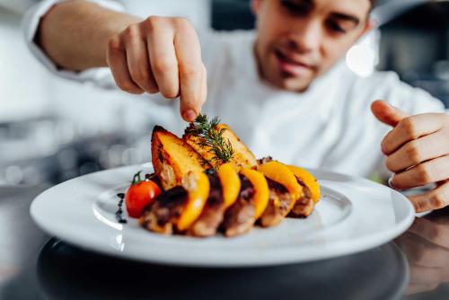 a man is pointing at a plate of food at BLACK AMBER BOUTIQUE HOTEL in Lampi