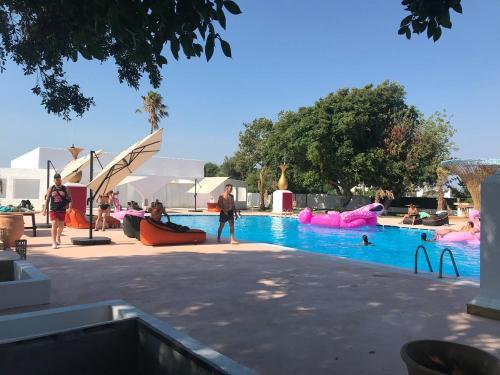 a group of people playing in a swimming pool at BLACK AMBER BOUTIQUE HOTEL in Lampi