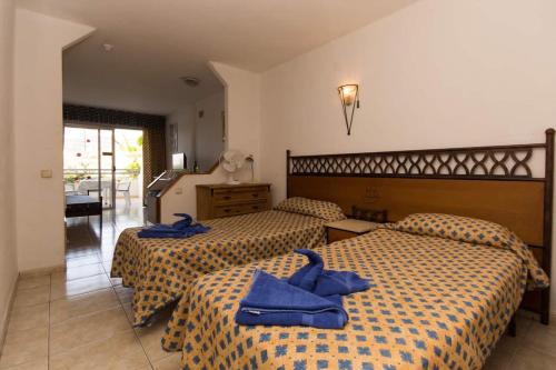 twee bedden in een hotelkamer met blauwe handdoeken erop bij Santa Maria 16 - Studio in Adeje