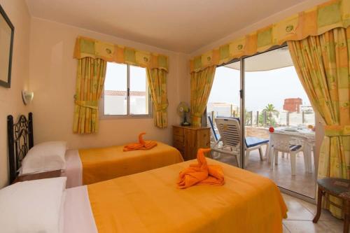 een slaapkamer met 2 bedden en oranje handdoeken bij Santa Maria 88 - Two Bed in Adeje
