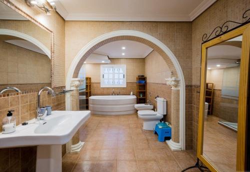 baño con 2 aseos, bañera y 2 lavabos en Villa Freesia with heated pool and air conditionin en San Miguel de Abona