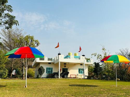 two colorful umbrellas in front of a house at The Bainada farm in Jaipur