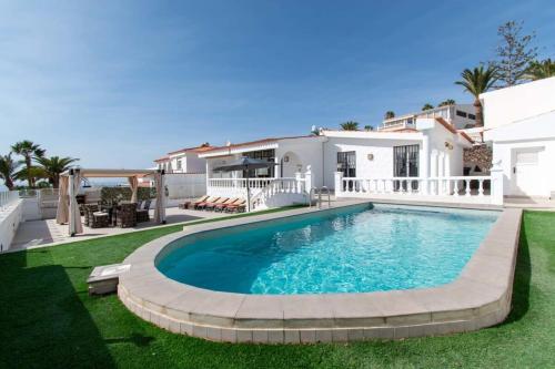 a swimming pool in the backyard of a house at Villa Melua in Chayofa