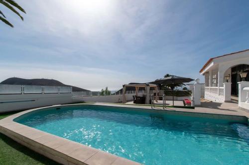a swimming pool in front of a house at Villa Melua in Chayofa