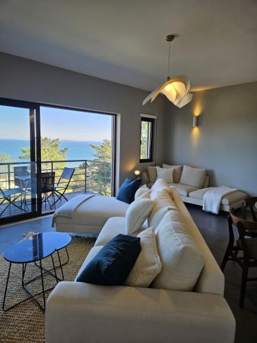 a living room with a white couch and a balcony at Soltroia Beach River & Golf in Grândola