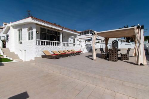 a patio with chairs and a canopy in front of a house at Villa Melua in Chayofa