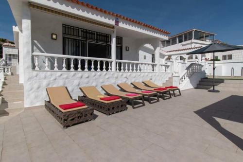 a group of chairs and an umbrella on a patio at Villa Melua in Chayofa