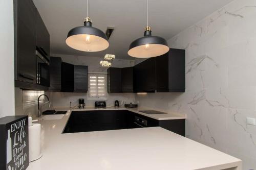 a kitchen with black cabinets and a white counter top at Villa Melua in Chayofa