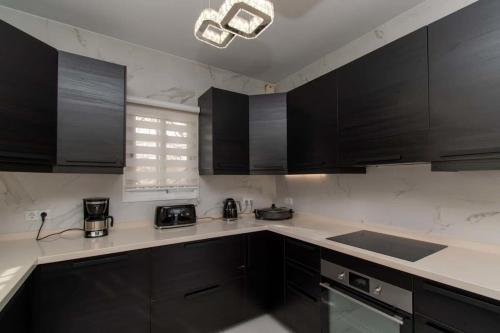 a kitchen with black cabinets and white counter tops at Villa Melua in Chayofa