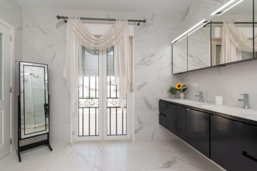 a white bathroom with a sink and a mirror at Villa Melua in Chayofa