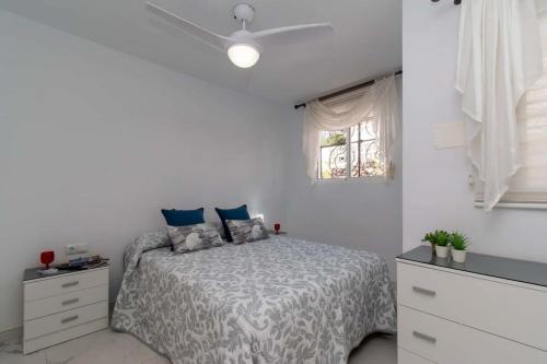 a white bedroom with a bed and a window at Villa Melua in Chayofa