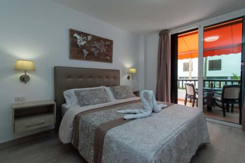 een slaapkamer met een bed met een wit dier erop bij Parque Santiago II 147 - Two Bed in Playa de las Americas
