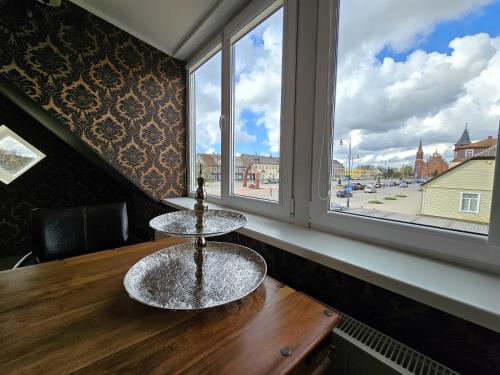 a table with two glass tables in a room with a window at Square apartments in Rokiškis