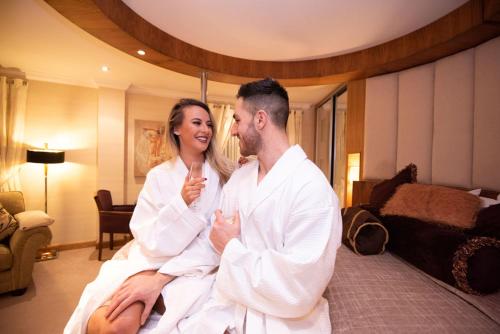 Ein Mann und eine Frau auf einem Bett in der Unterkunft The Villa Rose Hotel & V-Spa in Ballybofey