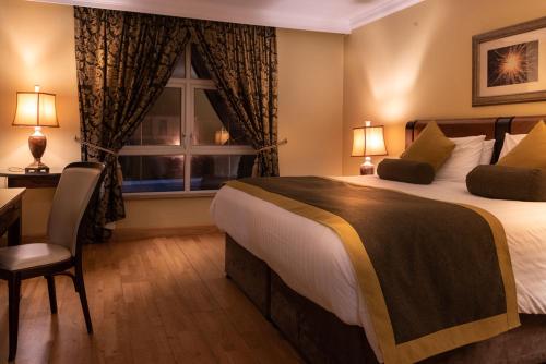 a hotel room with a large bed and a window at The Villa Rose Hotel & V-Spa in Ballybofey