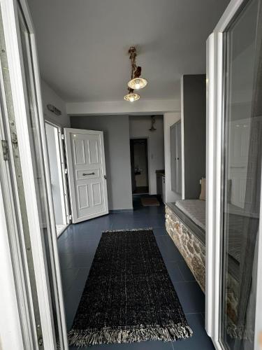 a hallway with a room with a door and a rug at Elenis Studios&Apartments in Masouri