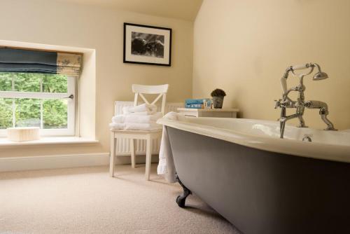 baño con bañera y ventana en Crailing Coach House, en Jedburgh