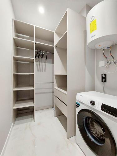 a white laundry room with a washer and dryer at Сучасні апартаменти в новобудові in Lviv