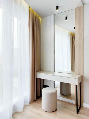 a dressing table and stool in a room with a mirror at Сучасні апартаменти в новобудові in Lviv