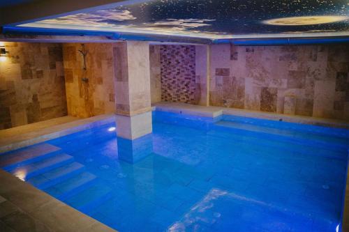 a large swimming pool with blue lighting at Хижа Марциганица in Asenovgrad