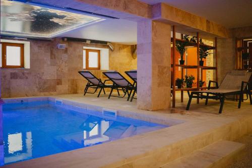 a pool with chairs and a table in a house at Хижа Марциганица in Asenovgrad