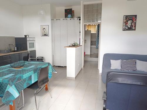 eine Küche und ein Wohnzimmer mit einem Tisch und einem Bett in der Unterkunft Quetzal in Perpignan