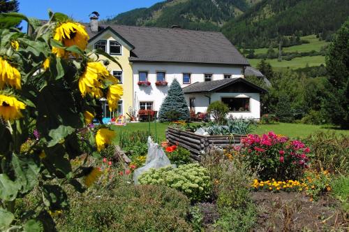 a house with a flower garden in front of it at Apartment Aineckblick in Sankt Michael im Lungau