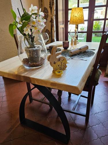 a wooden table with a vase of flowers on it at Logis Hostellerie Du Grand Duc hôtel restaurant in Gincla